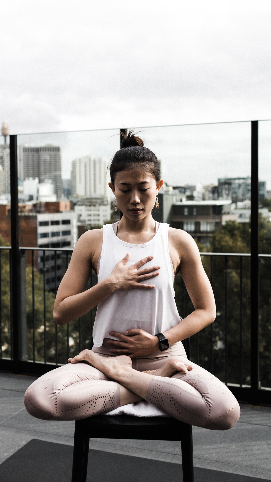 Woman doing yoga in office roof deck
